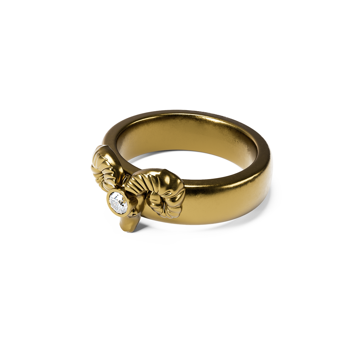 A silver ring with a small animal head and horn design, placed on a textured black rock surface.